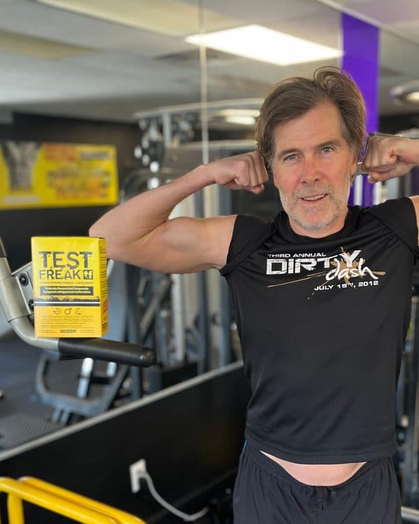 Scott after, flexing in the gym next to a box of Test Freak